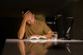 Young handsome man studying at home very bored and stressful reading a book at night Royalty Free Stock Photo