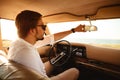 Young handsome man in sunglasses sitting inside his car Royalty Free Stock Photo