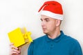 Young handsome man with surprise looks at the box with a gift. guy holds a strange present in his hands. negative emotions