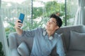 Young handsome man taking selfie wearing wireless headphones listening music Royalty Free Stock Photo