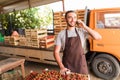 Young handsome man talk on phone with costumers in front collect tomatoes boxes at greenhouse. Online phone sales of tomato orders Royalty Free Stock Photo