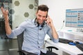 Young handsome man talking on phone in office. Royalty Free Stock Photo