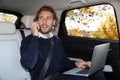 Young handsome man talking on phone while using laptop Royalty Free Stock Photo