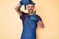 Young handsome man with tattoo wearing barber apron smiling making frame with hands and fingers with happy face Royalty Free Stock Photo