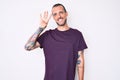 Young handsome man with tattoo wearing casual clothes showing and pointing up with fingers number four while smiling confident and Royalty Free Stock Photo