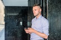 Young handsome man texting on cell phone outside office in New York City Royalty Free Stock Photo