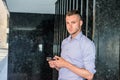 Young handsome man texting on cell phone outside office in New York City Royalty Free Stock Photo