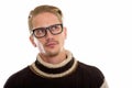 Young handsome man thinking and looking up while wearing eyeglas