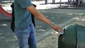 Young man tossing junk in garbage bin