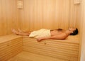 Young handsome man in a towel relaxing in sauna Royalty Free Stock Photo