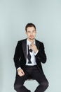 Young handsome man in a tuxedo, sitting and looking at the camera, bow tie undone Royalty Free Stock Photo