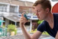 Young handsome man using asthma inhaler at home Royalty Free Stock Photo