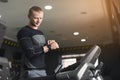 Young man using fitness tracker in gym