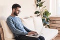 Young handsome man using laptop computer at home. Student men resting  in his room. Royalty Free Stock Photo