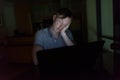 Young handsome man using laptop in the dark living room Royalty Free Stock Photo