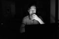 Young handsome man using laptop in the dark living room Royalty Free Stock Photo