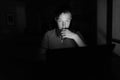 Young handsome man using laptop in the dark living room Royalty Free Stock Photo