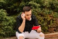 Young handsome man using smartphone in a city. Smiling male student texting on his mobile phone. Rest. Modern lifestyle concept Royalty Free Stock Photo