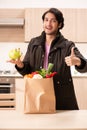 The young handsome man with vegetables in the kitchen Royalty Free Stock Photo