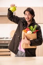 The young handsome man with vegetables in the kitchen Royalty Free Stock Photo