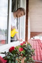 Young handsome man with watering can take care of home plants, gardening concept Royalty Free Stock Photo