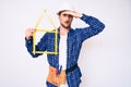 Young handsome man wearing architect hardhat holding build project stressed and frustrated with hand on head, surprised and angry Royalty Free Stock Photo