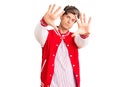 Young handsome man wearing baseball uniform doing frame using hands palms and fingers, camera perspective Royalty Free Stock Photo