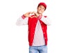 Young handsome man wearing baseball uniform smiling in love showing heart symbol and shape with hands