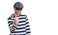 Young handsome man wearing burglar mask beckoning come here gesture with hand inviting welcoming happy and smiling Royalty Free Stock Photo