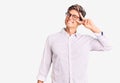 Young handsome man wearing business clothes and glasses doing peace symbol with fingers over face, smiling cheerful showing Royalty Free Stock Photo