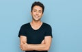 Young handsome man wearing casual black t shirt happy face smiling with crossed arms looking at the camera Royalty Free Stock Photo