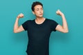 Young handsome man wearing casual black t shirt showing arms muscles smiling proud Royalty Free Stock Photo