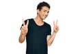 Young handsome man wearing casual black t shirt smiling looking to the camera showing fingers doing victory sign Royalty Free Stock Photo