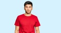 Young handsome man wearing casual red tshirt relaxed with serious expression on face Royalty Free Stock Photo