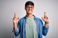 Young handsome man wearing casual shirt and glasses over isolated white background gesturing finger crossed smiling with hope and Royalty Free Stock Photo