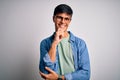 Young handsome man wearing casual shirt and glasses over isolated white background looking confident at the camera with smile with Royalty Free Stock Photo