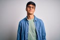 Young handsome man wearing casual shirt and glasses over isolated white background Relaxed with serious expression on face Royalty Free Stock Photo