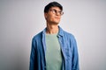 Young handsome man wearing casual shirt and glasses over isolated white background smiling looking to the side and staring away Royalty Free Stock Photo