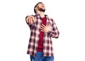 Young handsome man wearing casual shirt laughing at you, pointing finger to the camera with hand over body, shame expression Royalty Free Stock Photo