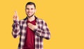 Young handsome man wearing casual shirt smiling swearing with hand on chest and fingers up, making a loyalty promise oath Royalty Free Stock Photo