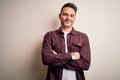 Young handsome man wearing casual shirt standing over isolated white background happy face smiling with crossed arms looking at Royalty Free Stock Photo