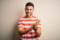 Young handsome man wearing casual striped t-shirt standing over isolated white background clapping and applauding happy and Royalty Free Stock Photo