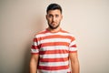 Young handsome man wearing casual striped t-shirt standing over isolated white background depressed and worry for distress, crying Royalty Free Stock Photo