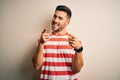 Young handsome man wearing casual striped t-shirt standing over isolated white background pointing fingers to camera with happy Royalty Free Stock Photo