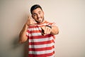Young handsome man wearing casual striped t-shirt standing over isolated white background smiling doing talking on the telephone Royalty Free Stock Photo