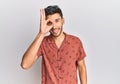 Young handsome man wearing casual summer clothes doing ok gesture with hand smiling, eye looking through fingers with happy face Royalty Free Stock Photo