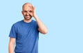 Young handsome man wearing casual t shirt doing ok gesture with hand smiling, eye looking through fingers with happy face Royalty Free Stock Photo