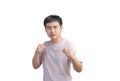 Young handsome man wearing casual t-shirt over white background. Punching fist to fight, aggressive and angry attack, threat and Royalty Free Stock Photo