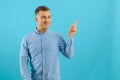 Young handsome man wearing casual t-shirt smiling happy pointing with his thumbs and indicate fingers at copy space over blue Royalty Free Stock Photo