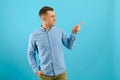 Young handsome man wearing casual t-shirt smiling happy pointing with his thumbs and indicate fingers at copy space over blue Royalty Free Stock Photo